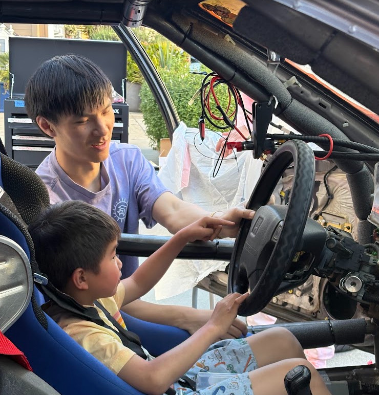 Neighbors and kids stop by to learn about building race cars.